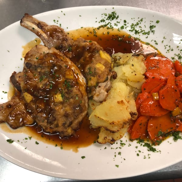 Two Happy Days Finer Diner pork chops with gravy, roasted potatoes, and red peppers.