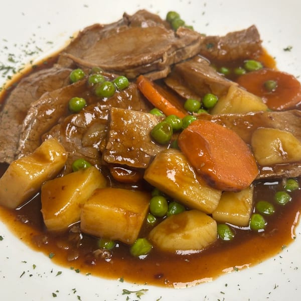 Happy Days Finer Diner's pot roast with sliced beef, potatoes, carrots, and peas in gravy.